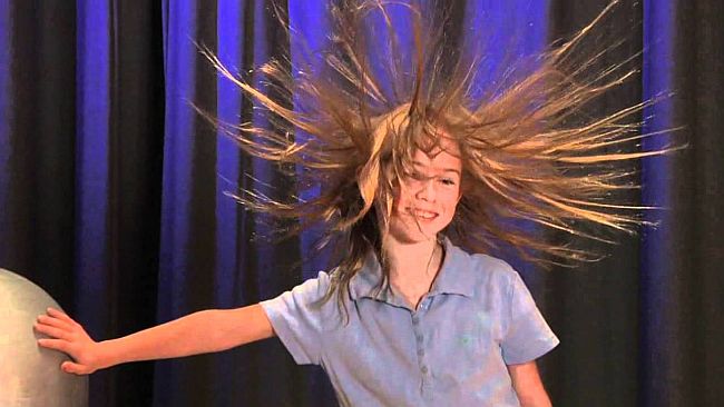 child with static hair from Van der Graaff generator